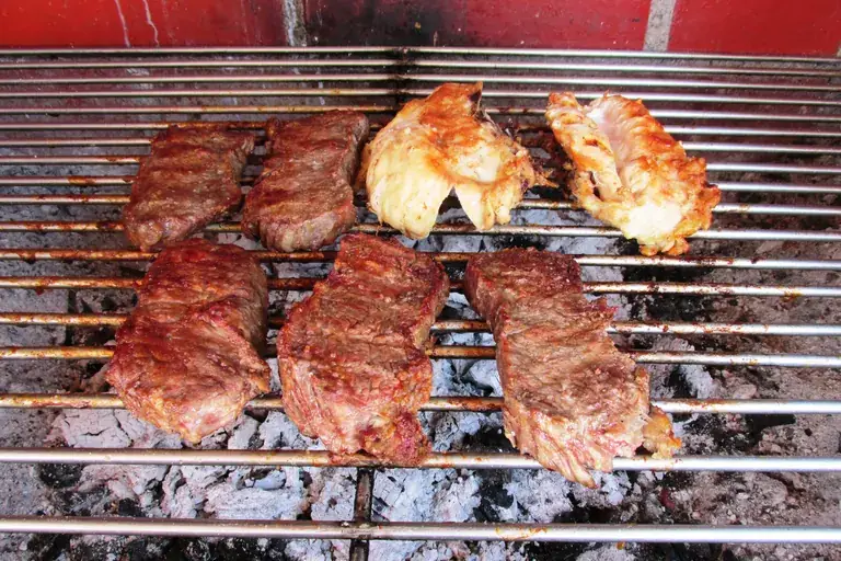 Meat and chicken on a Chilean asado grill