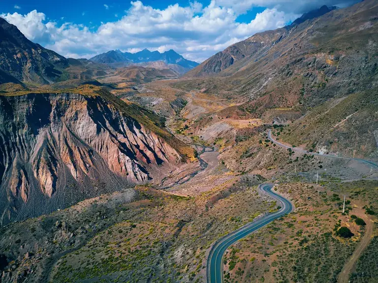 The road winding through the Cajón del Maipo between the mountains