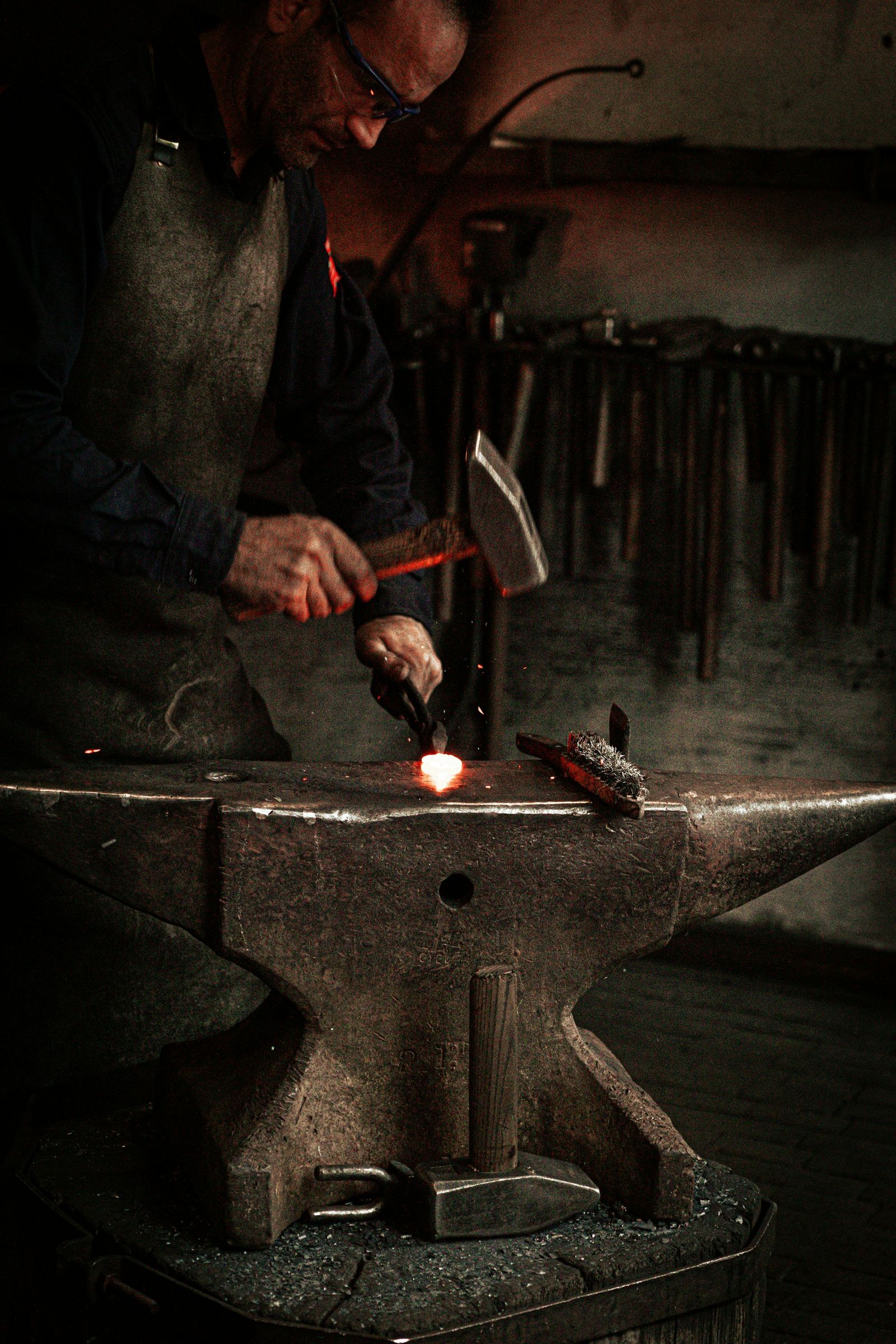 An artisan working metal on an anvil