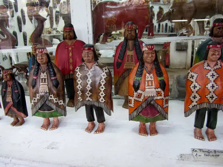 Hand-carved wooden figures in traditional dress at Pueblito Los Dominicos