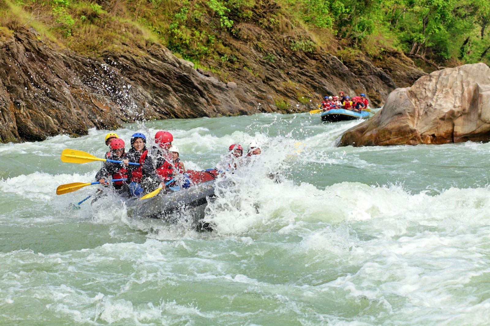 A raft crew paddling through white-water rapids